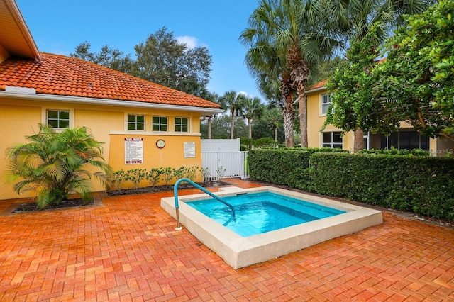 view of pool with a hot tub