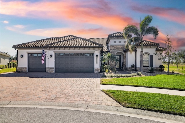 mediterranean / spanish house featuring a garage and a lawn