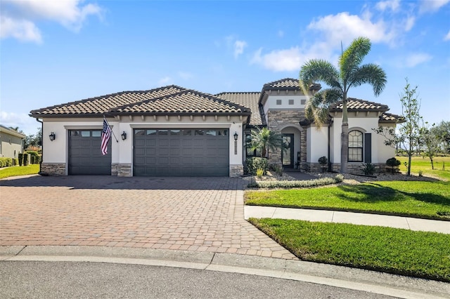 mediterranean / spanish house with a garage and a front lawn