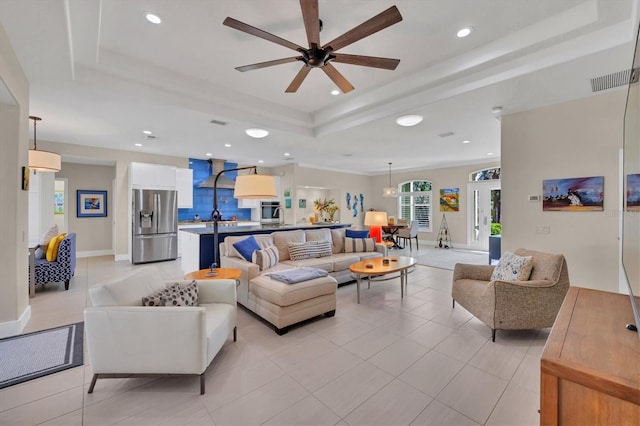 tiled living room featuring a tray ceiling and ceiling fan