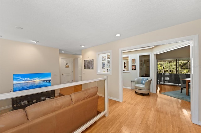 living room featuring light hardwood / wood-style floors and a textured ceiling