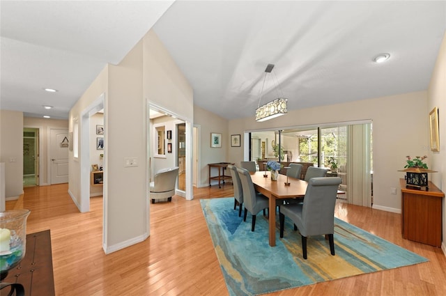 dining room with lofted ceiling and light hardwood / wood-style flooring