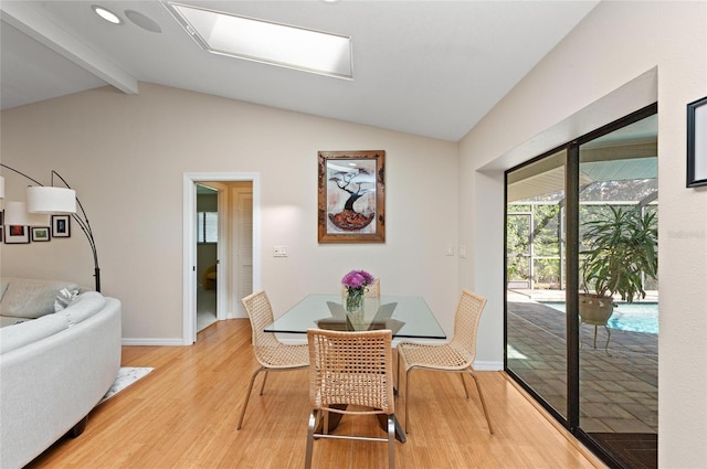 dining area featuring lofted ceiling with beams and light hardwood / wood-style floors