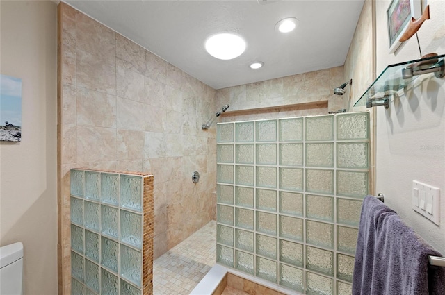 bathroom featuring toilet and tiled shower