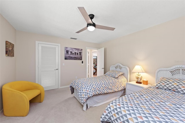 carpeted bedroom with ceiling fan and a closet