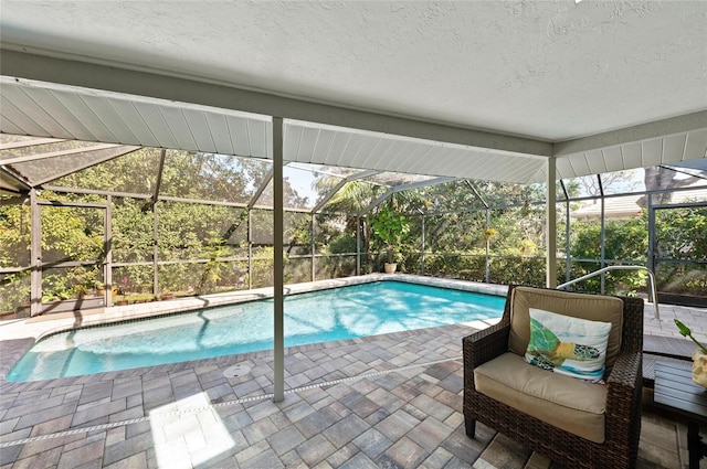 view of pool with a patio and glass enclosure