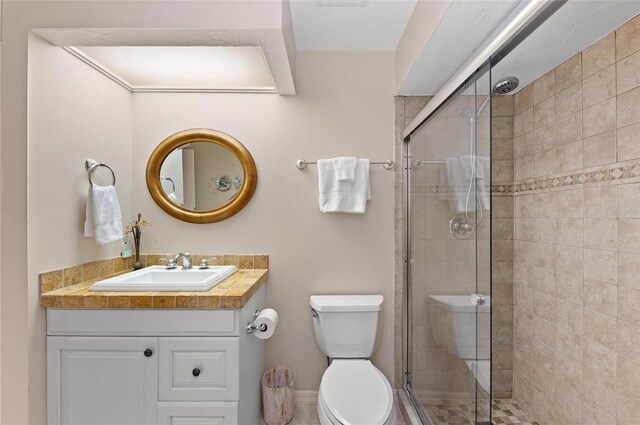 bathroom featuring a stall shower, baseboards, toilet, and vanity