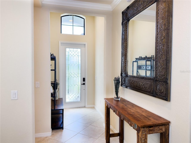 tiled foyer entrance with crown molding and baseboards