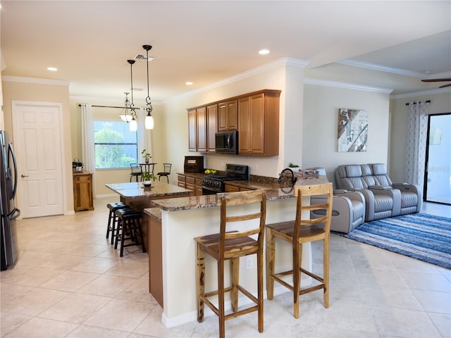 kitchen with a kitchen breakfast bar, dark stone countertops, open floor plan, a peninsula, and black appliances