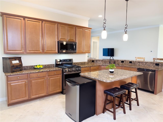 kitchen with a breakfast bar area, a peninsula, ornamental molding, appliances with stainless steel finishes, and dark stone countertops