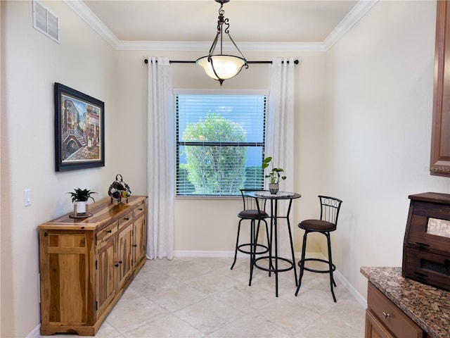 dining room with baseboards, visible vents, and crown molding