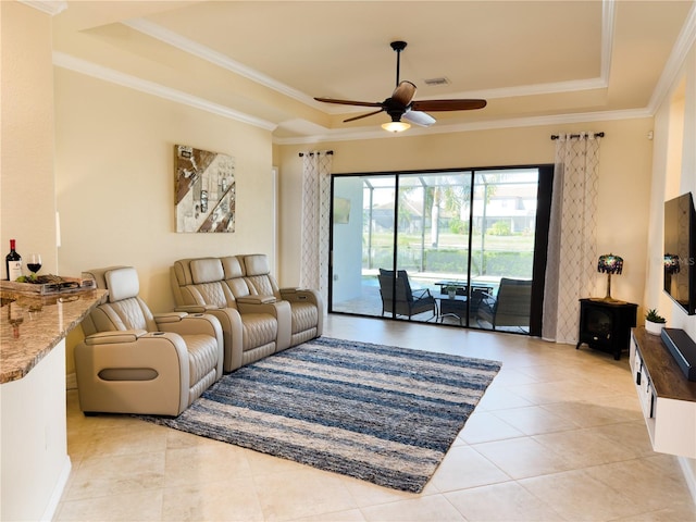 living area featuring ceiling fan, a tray ceiling, and crown molding