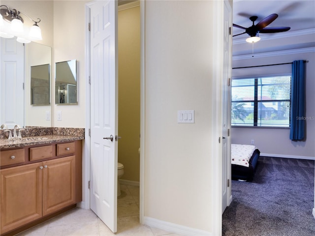 bathroom featuring crown molding, toilet, a ceiling fan, vanity, and tile patterned flooring