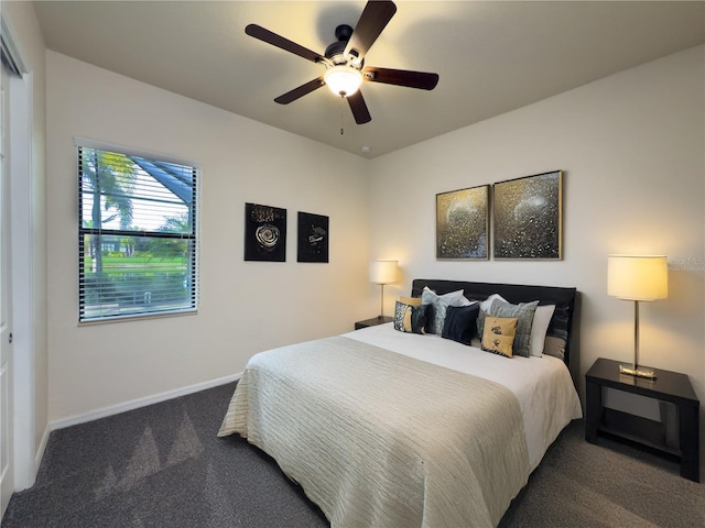 bedroom with dark colored carpet, a ceiling fan, and baseboards