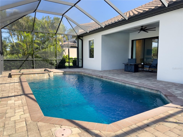 outdoor pool featuring a patio area, ceiling fan, and glass enclosure