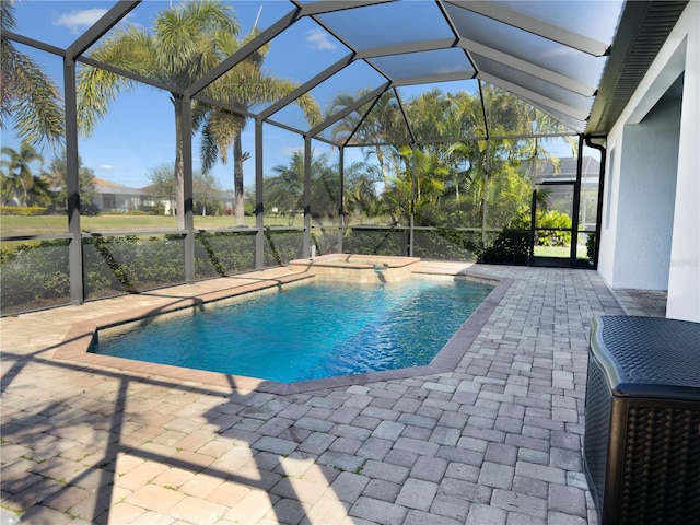 view of pool featuring a lanai, a patio area, and a pool with connected hot tub