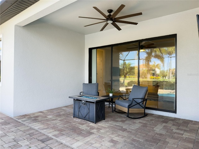 view of patio / terrace with an outdoor fire pit and a ceiling fan