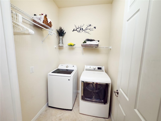 laundry room featuring laundry area, light tile patterned floors, baseboards, and separate washer and dryer