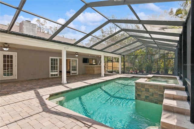 view of pool with a patio area, a ceiling fan, a lanai, and a pool with connected hot tub