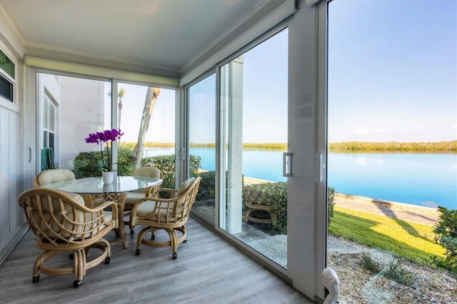 sunroom featuring a water view