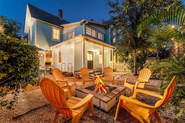 rear view of property with a fire pit and a patio area