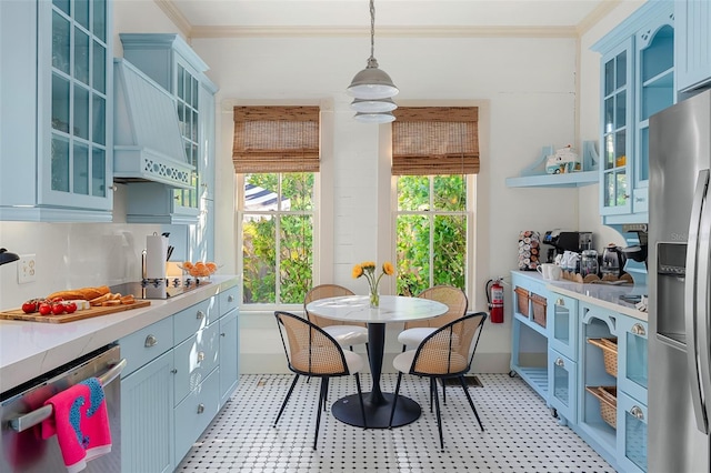 kitchen with premium range hood, appliances with stainless steel finishes, crown molding, and pendant lighting