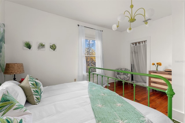 bedroom featuring hardwood / wood-style floors and a notable chandelier