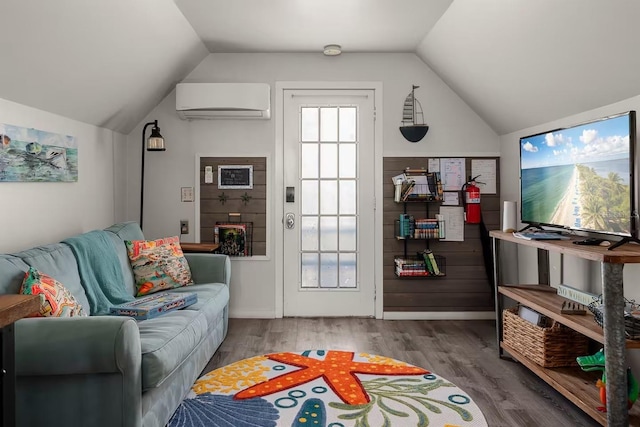 living room with lofted ceiling, hardwood / wood-style flooring, and an AC wall unit