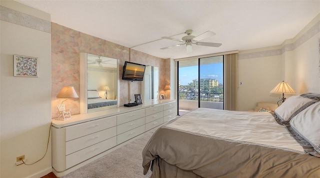 bedroom with access to outside, light colored carpet, expansive windows, and ceiling fan