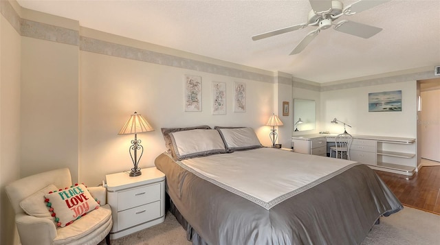 bedroom featuring ceiling fan, a textured ceiling, and light wood-type flooring