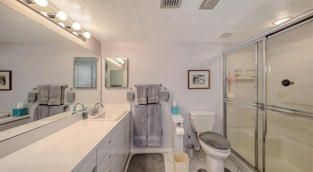 bathroom featuring vanity, toilet, a shower with door, tile patterned floors, and a textured ceiling