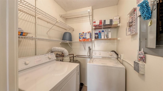 laundry area with a textured ceiling and washing machine and clothes dryer