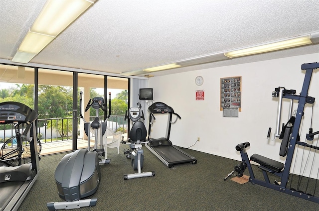 gym featuring a wall of windows and a textured ceiling