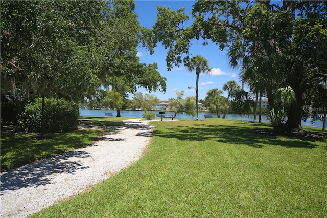 surrounding community featuring a water view and a lawn