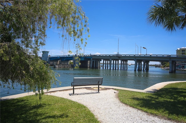 view of dock featuring a lawn and a water view