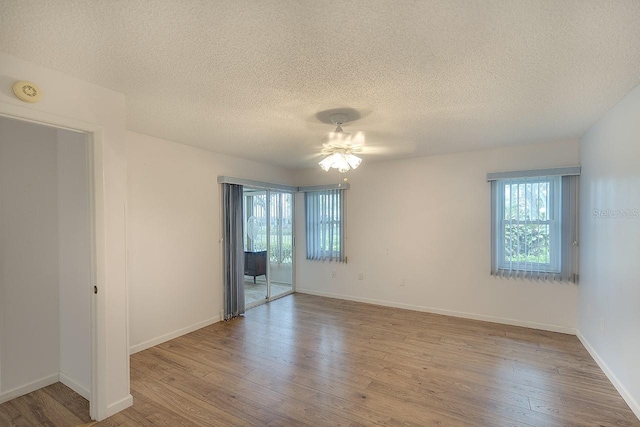 interior space featuring a textured ceiling, baseboards, and wood finished floors