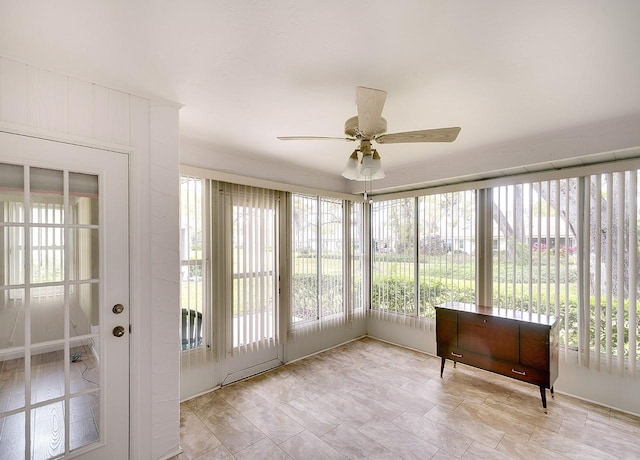 unfurnished sunroom with a ceiling fan