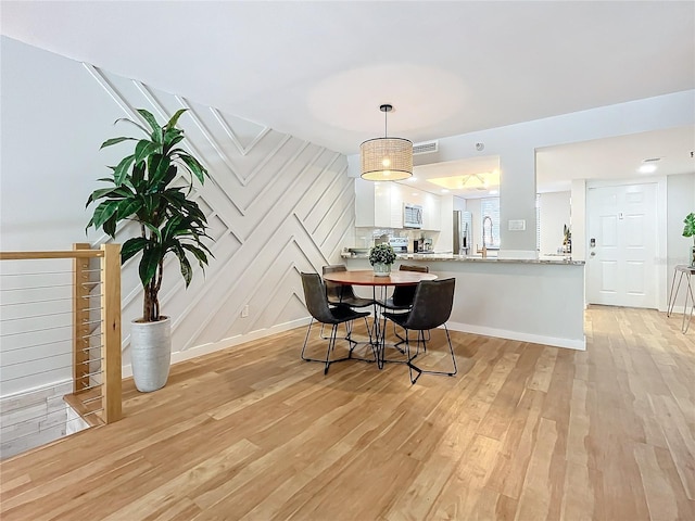 dining space featuring sink and light wood-type flooring