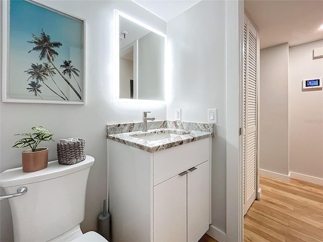 bathroom with vanity, toilet, and hardwood / wood-style floors