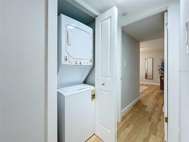 washroom featuring stacked washer / drying machine and light hardwood / wood-style floors