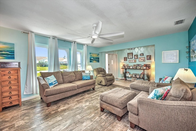 living room featuring visible vents, ceiling fan, and wood finished floors