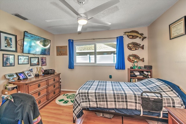 1413 SE 36th St, Cape Coral, FL 33904 - bedroom with visible vents, a textured ceiling, a ceiling fan, and wood finished floors