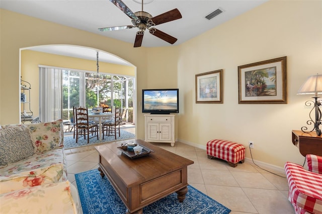 tiled living room featuring ceiling fan with notable chandelier