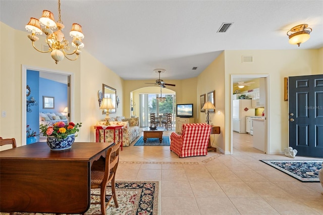 dining space with ceiling fan with notable chandelier and light tile patterned floors