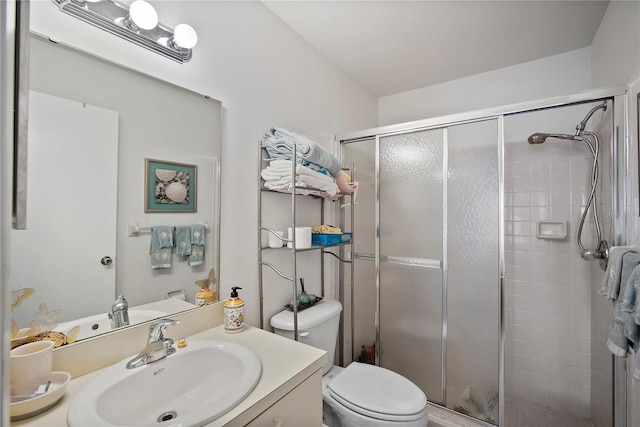 bathroom with an enclosed shower, vanity, and toilet