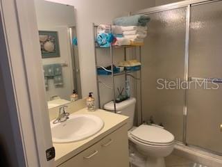 bathroom with vanity, toilet, and an enclosed shower