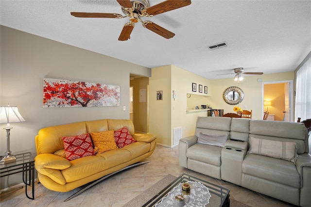 tiled living room with ceiling fan and a textured ceiling