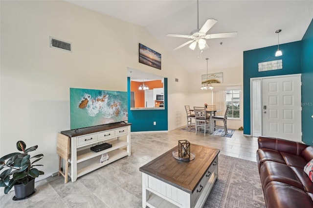 living room with ceiling fan with notable chandelier and high vaulted ceiling