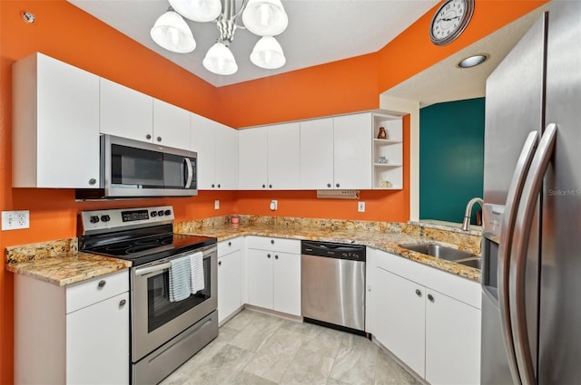 kitchen featuring white cabinetry, sink, pendant lighting, and appliances with stainless steel finishes