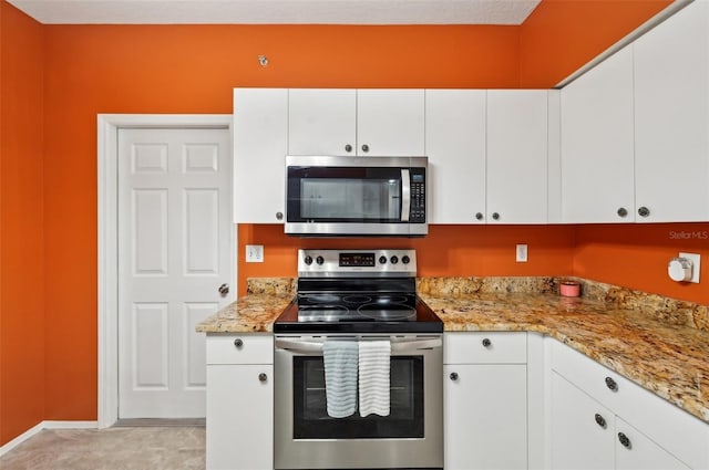 kitchen featuring light stone countertops, white cabinetry, and appliances with stainless steel finishes